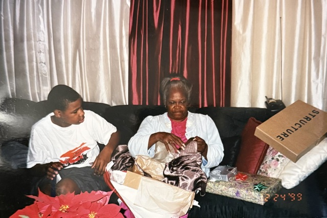 Family members opening presents together on a couch