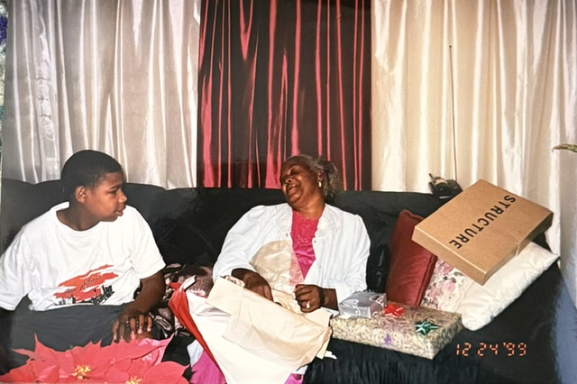 Two family members laughing while opening gifts